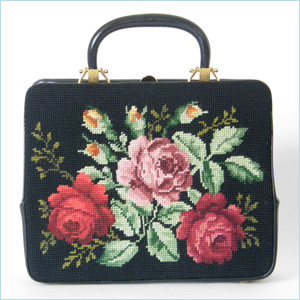Colorful, Rosenfeld handbag with chunky gold plated hardware and needlepoint side panels with red and pink roses  black faille lined interior has two large slip pockets and one zippered pocket; has a matching little coin purse and small mirror  marked; Rosenfeld  12.75 w x 3.5 d x 10.25 h, 13.5 h to top of handle  excellent condition, slight bend to leather handle  $350. 